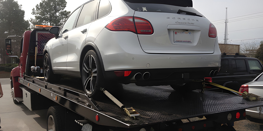 Image of Hooked-Up Towing & Recovery Towing Truck with Car in the back